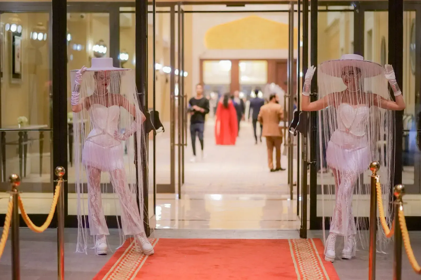 Fringe-veiled hostesses greet guests