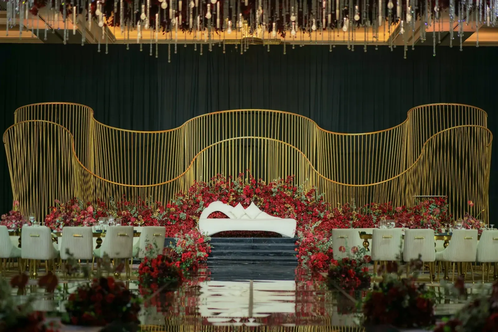 Gold wire-work stage and red roses at the Kenza and Asad reception